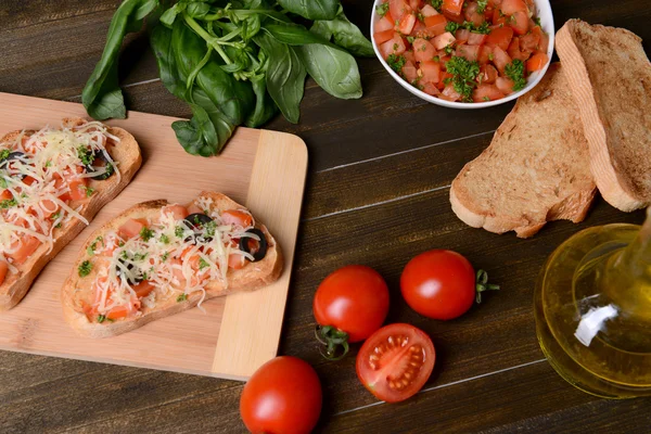 Finom bruschetta paradicsommal a vágódeszkán közelkép — Stock Fotó