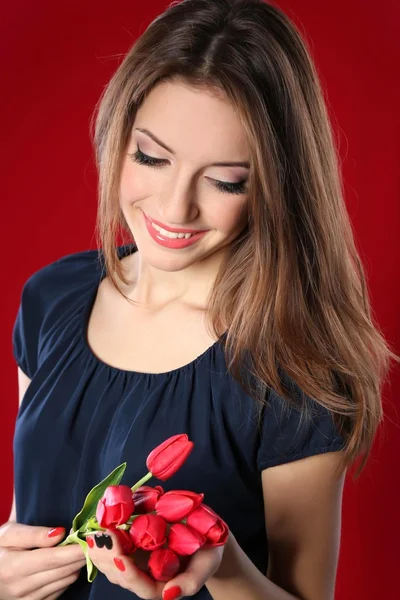 Mujer atractiva con flores sobre fondo de color — Foto de Stock