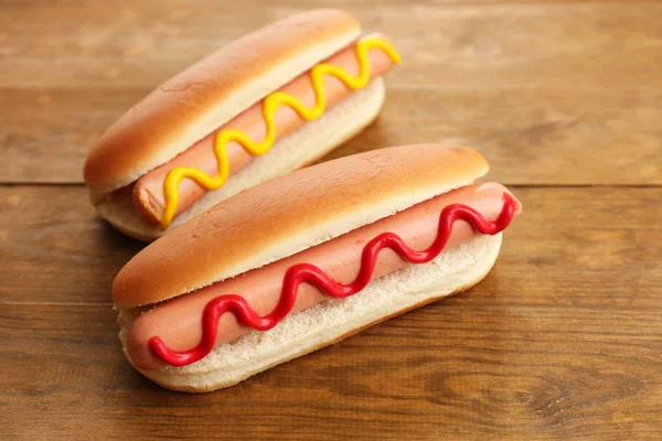 Tasty hot dogs on wooden table — Stock Photo, Image