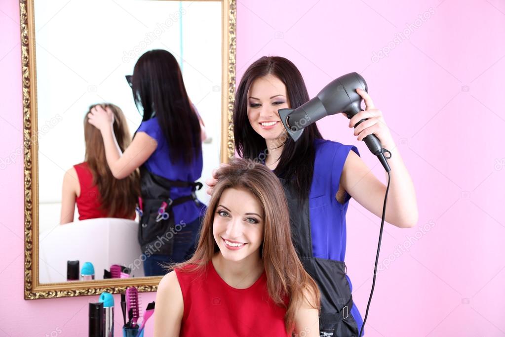 Beautiful woman hairdresser do hairstyle girl in beauty salon