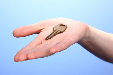 anahtarı elinde mavi zemin üzerine