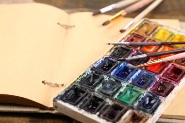 renkli suluboya, fırçalar ve ahşap zemin üzerinde sketcher kompozisyonu 