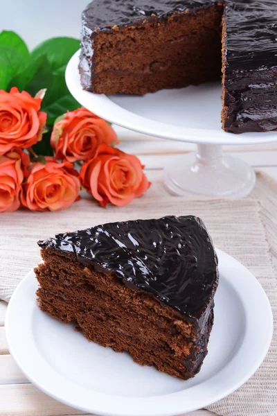 Deliziosa torta al cioccolato sul piatto sul tavolo su sfondo chiaro — Foto Stock