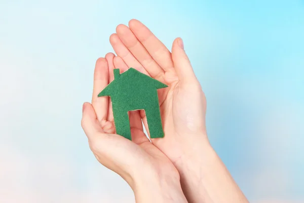 Petite maison en papier à la main gros plan, sur fond clair — Photo