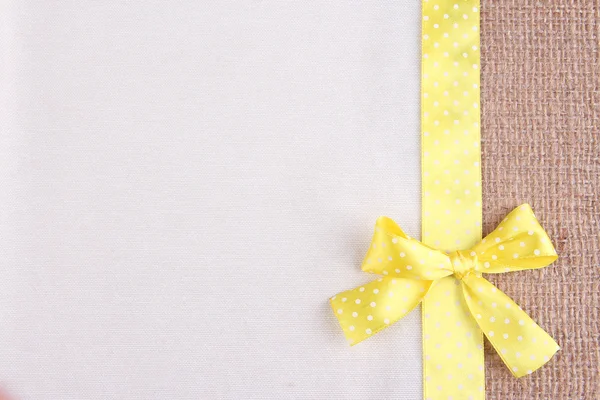 Pytloviny s color ribbon a luk na pozadí barevných tkanin — Stock fotografie
