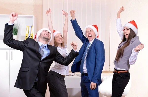 Successful young businesspeople at Santa hat at office — Stock Photo, Image