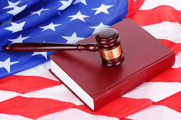 Giudice martelletto e libro su sfondo bandiera americana — Foto Stock