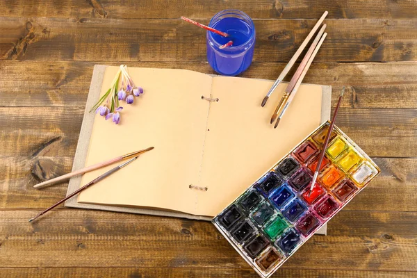 Komposition mit farbenfrohen Aquarellen, Pinseln und Skizzen auf Holzgrund — Stockfoto