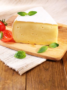 smakelijke camembert kaas met tomaat en basilicum, op houten tafel