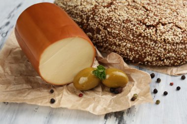 Ahşap masada lezzetli füme peynir ve ekmek.