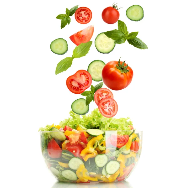 Frisches gemischtes Gemüse fällt in Schüssel mit Salat isoliert auf weiß — Stockfoto