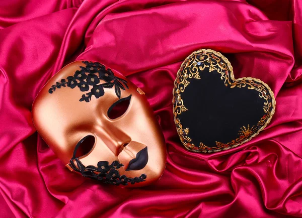 Cuore nero decorativo e maschera, su tessuto a colori — Foto Stock