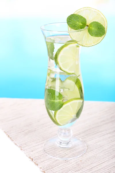 Glas cocktail met limoen en munt op tafel op lichte blauwe achtergrond — Stockfoto