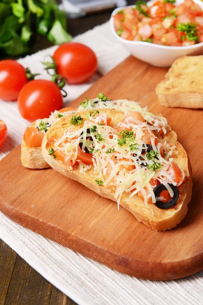 Läcker bruschetta med tomater på skärbräda närbild — Stockfoto