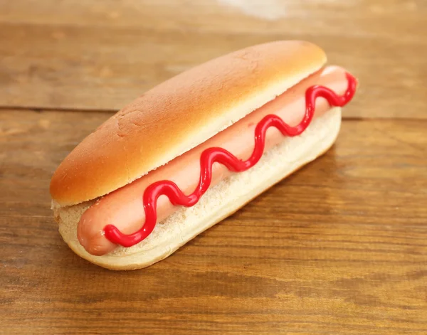 Tasty hot dog on wooden table — Stock Photo, Image