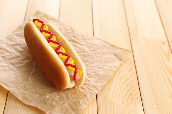 Tasty hot dog on wooden table — Stock Photo, Image