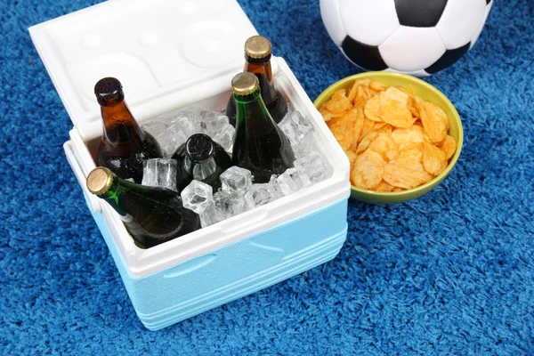 Ice chest full of drinks in bottles on color carpet background — Stock Photo, Image