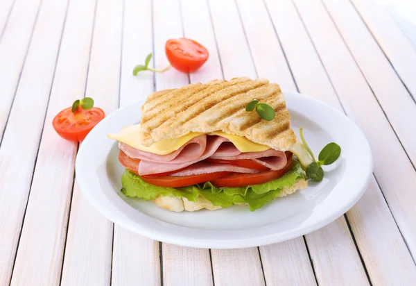 Sabroso sándwich con jamón sobre mesa de madera — Foto de Stock