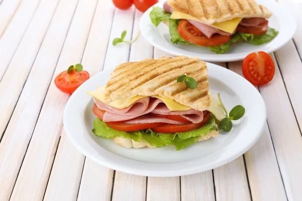 Leckeres Sandwich mit Schinken auf Holztisch — Stockfoto