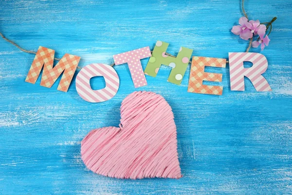 Mother- lettering of handmade paper letters on blue wooden background — Stock Photo, Image