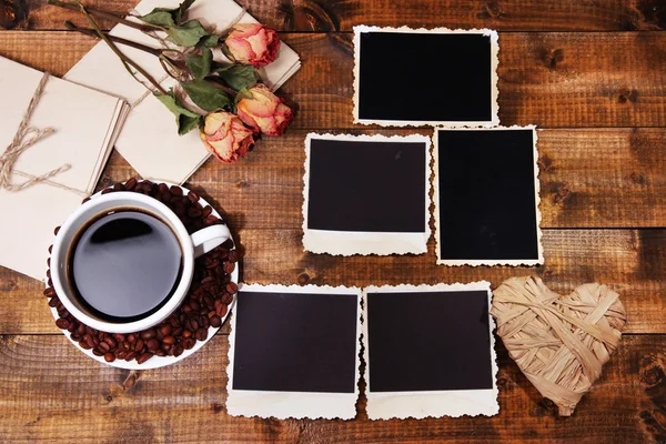 Taza de café y viejas fotos en blanco, sobre fondo de madera — Foto de Stock