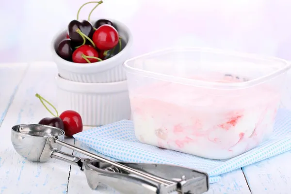 Helado en recipiente y cuchara de helado en mesa de madera de primer plano — Foto de Stock