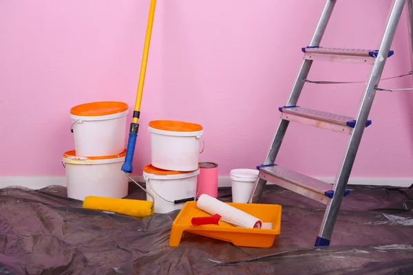 Cubos con pintura y escalera sobre fondo de pared. Foto conceptual de los trabajos de reparación en la habitación — Foto de Stock