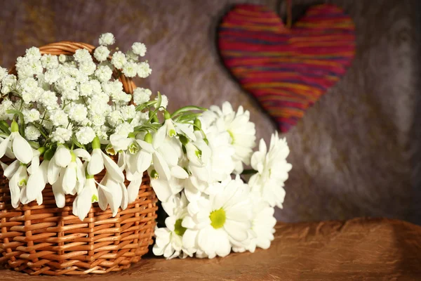 Beaux gouttes de neige dans le panier avec coeur, sur fond brun — Photo