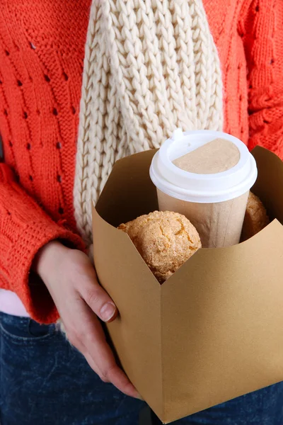 Woman holds box with coffee and cookies close-up — Stock Photo, Image