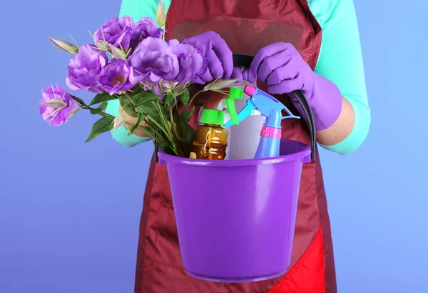 Femme au foyer tenant seau avec équipement de nettoyage sur fond de couleur. Photo conceptuelle du nettoyage du printemps . — Photo