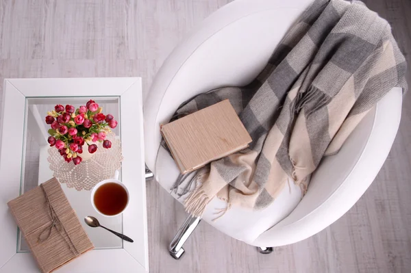 Composición con taza de bebida caliente y galletas en mesa de madera cerca del sillón — Foto de Stock