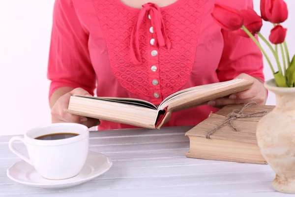 Vrouw leest boek en drinken koffie, close-up — Stockfoto
