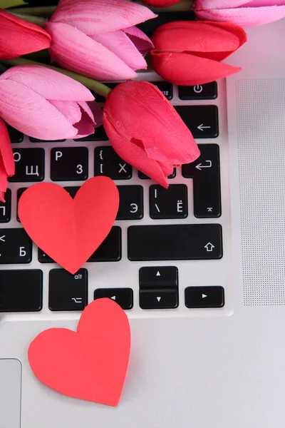 Corazones rojos y flores en el teclado de la computadora de cerca — Foto de Stock