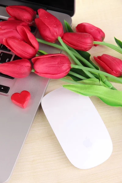 Computadora con corazón rojo y flores en la mesa de cerca — Foto de Stock