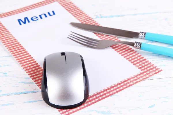 Computer mouse with menu and cutlery on wooden background — Stock Photo, Image