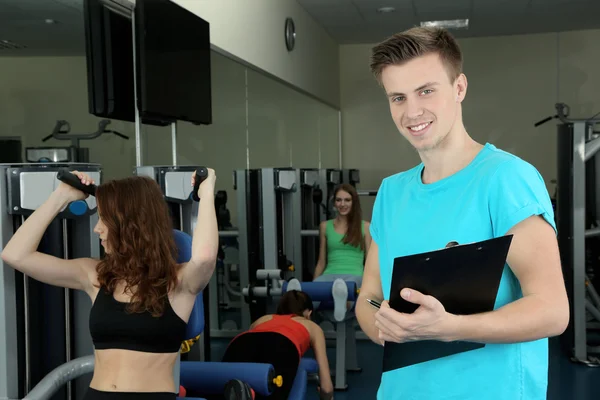 Mädchen und Trainer im Simulator in Turnhalle beschäftigt — Stockfoto