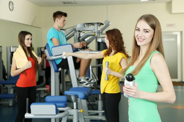 Ung kvinnas bedriver simulator i gym — Stockfoto
