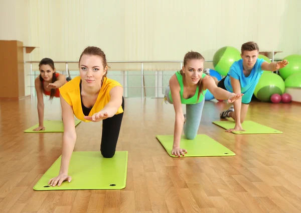 Jóvenes hermosas personas que participan en el gimnasio — Foto de Stock