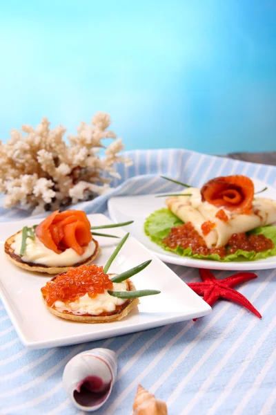 Panqueques con caviar rojo, salmón y mayonesa, cebolla verde, sobre plato, sobre servilleta de color, sobre mesa de madera, sobre fondo brillante — Foto de Stock