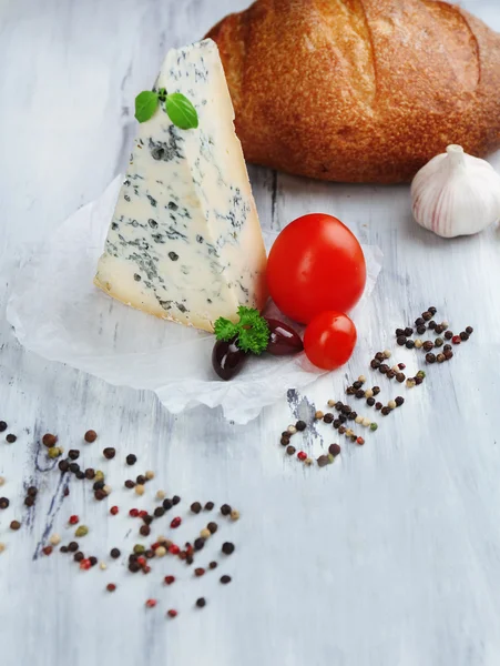 Queijo azul saboroso e pão na velha mesa de madeira — Fotografia de Stock