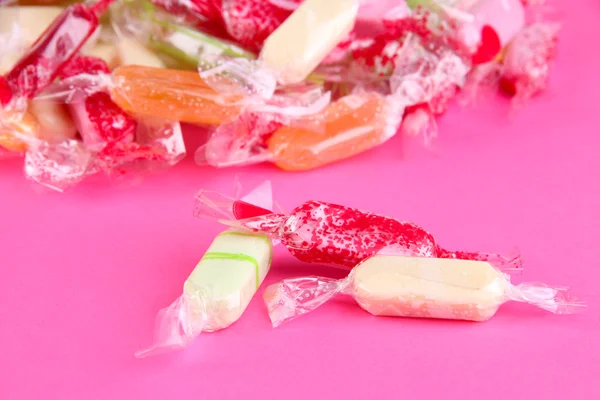Caramelle gustose su sfondo rosa — Foto Stock