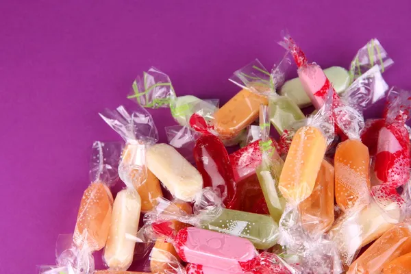 Tasty candies on purple background — Stock Photo, Image