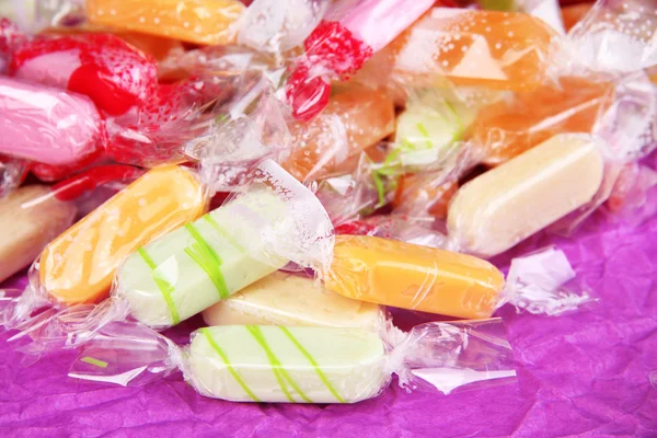 Смачні цукерки на фіолетовому фоні — стокове фото