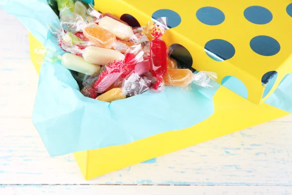 Tasty candies in present box on wooden background — Stock Photo, Image