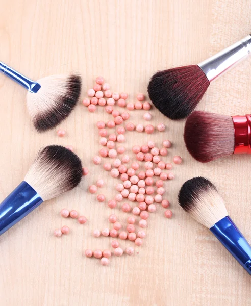 Powder balls and brushes on wooden background — Stock Photo, Image