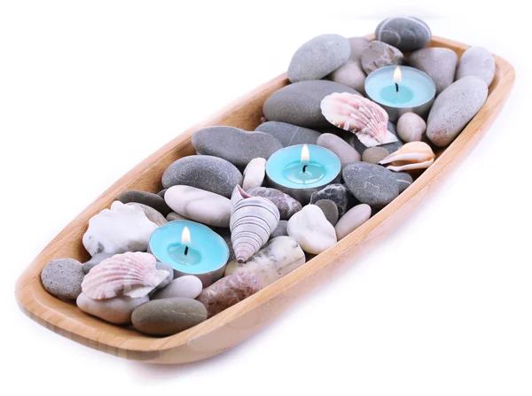 Drewniana miska spa kamieni, muszli i świece na białym tle — Zdjęcie stockowe