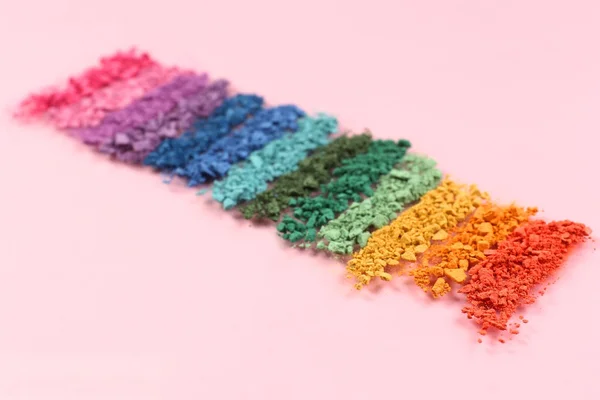 Rainbow crushed eyeshadow on pink background — Stock Photo, Image