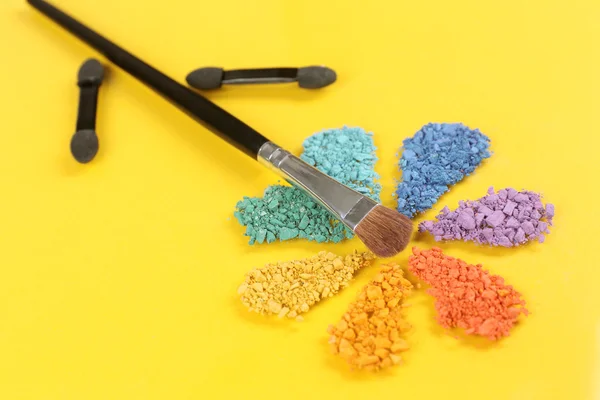 Fard à paupières écrasé arc-en-ciel en forme de fleur sur fond jaune — Photo