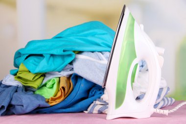 demir ve tablo parlak arka plan üzerinde renkli elbise yığını