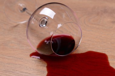 gekanteld glas wijn op vloer close-up